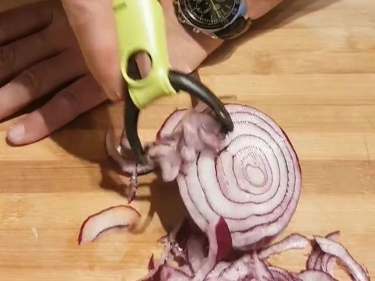 Slicing red onion with a peeler