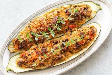 Italian zucchini recipe of two sausage stuffed zucchini on a platter.