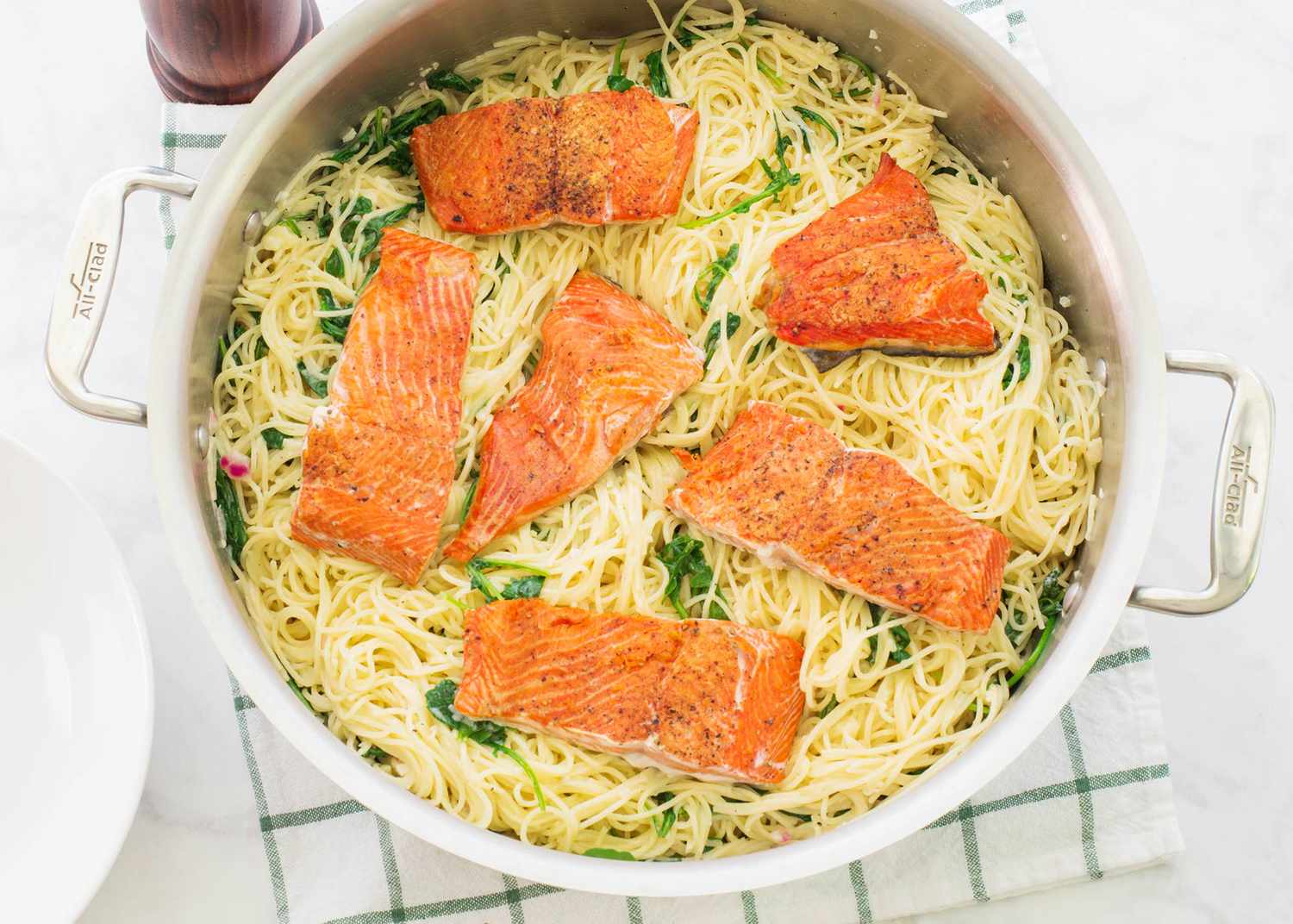 Angel Hair Pasta with Salmon, Arugula, and Creamy Lemon-Parmesan Sauce in a saucepan