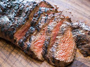 Grilled Marinated Flank Steak sliced on a cutting board