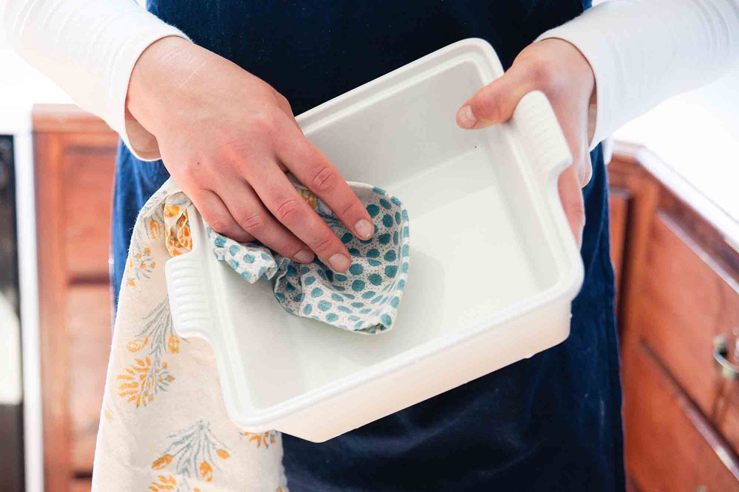 Stoneware Casserole Dish Wiped with a Kitchen Towel