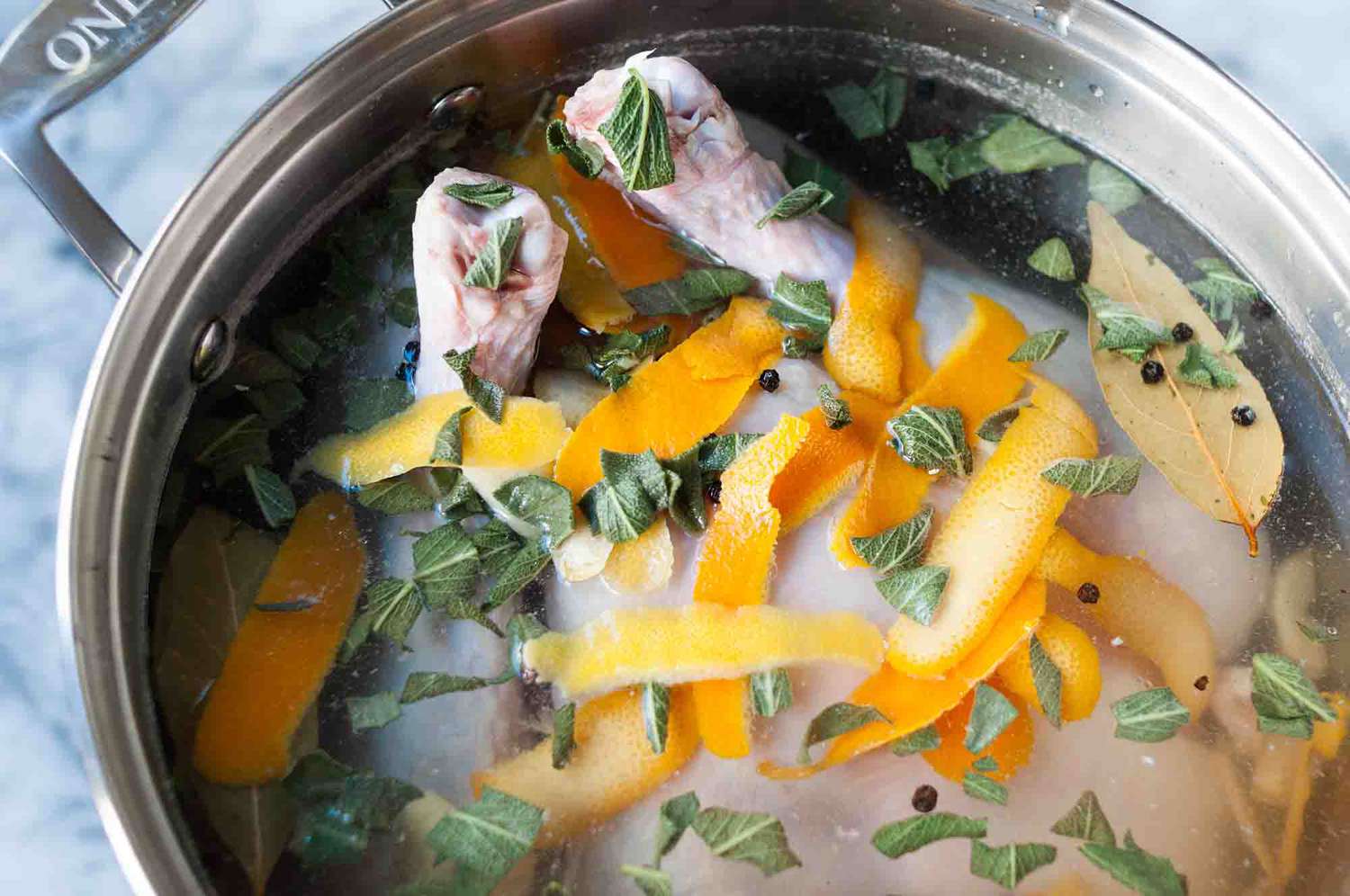 A turkey resting in a pot filled with a brine