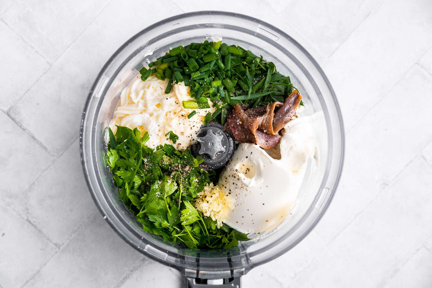 Homemade Green Goddess Dressing Ingredients (Herbs, Mayonnaise, Sour Cream, Garlic, etc) in a Food Processor 