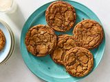 Platter of molasses spice cookies, one plated cookie, and a glass of milk