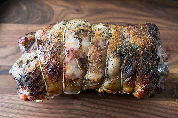 Cooked roasted leg of lamb on butcher block