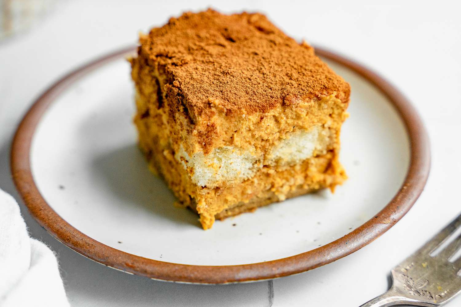 Slice of Pumpkin Tiramisu on a Plate Next to a Fork