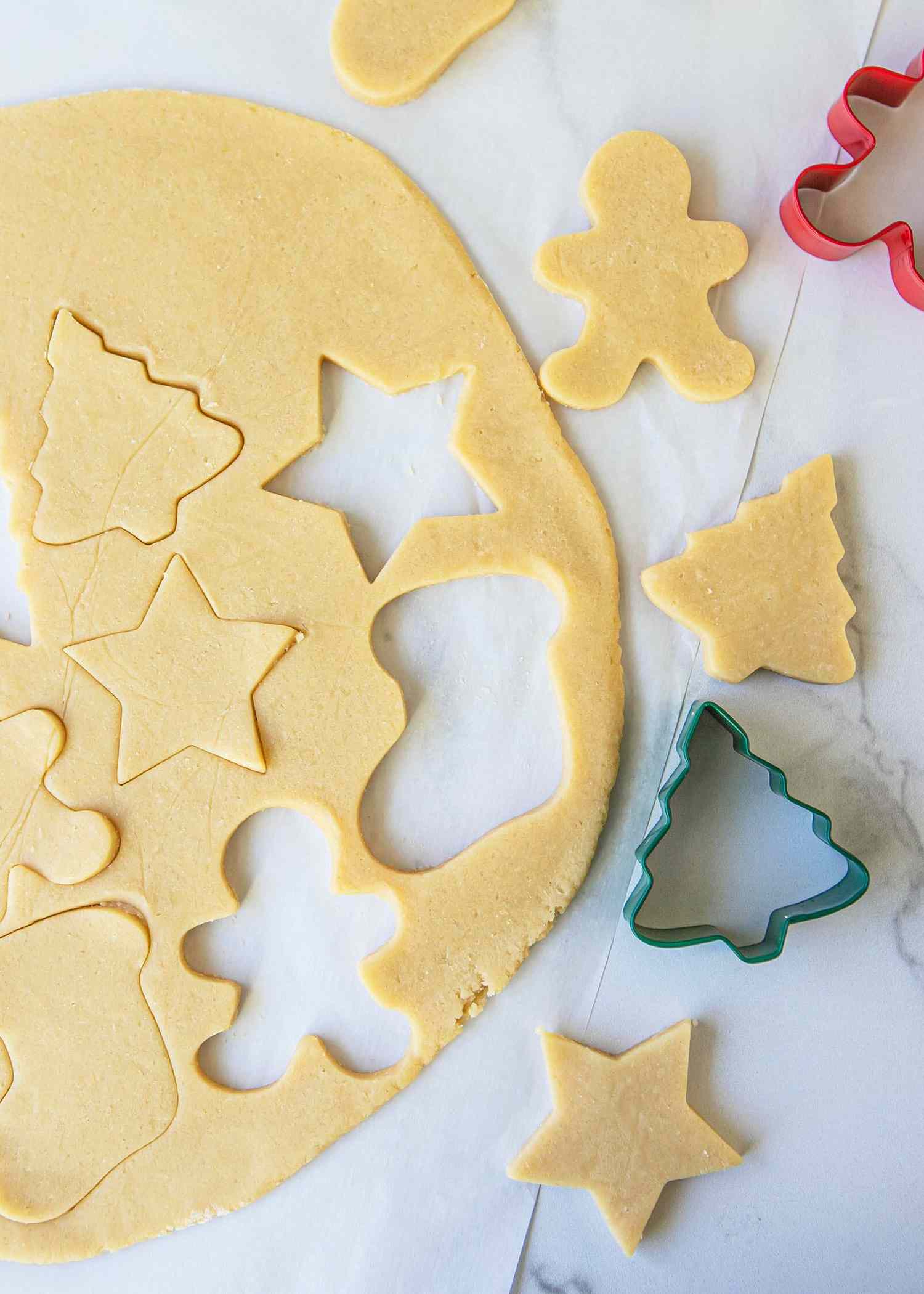 holiday cookies being cut out using a cookie cutter