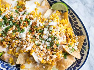Bowl of Mexican Street Corn Nachos Served With Lime Wedges