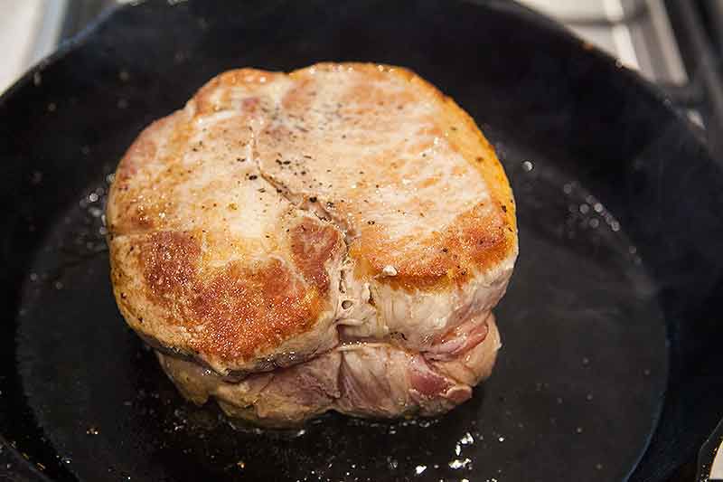 Pork roast searing in a pan