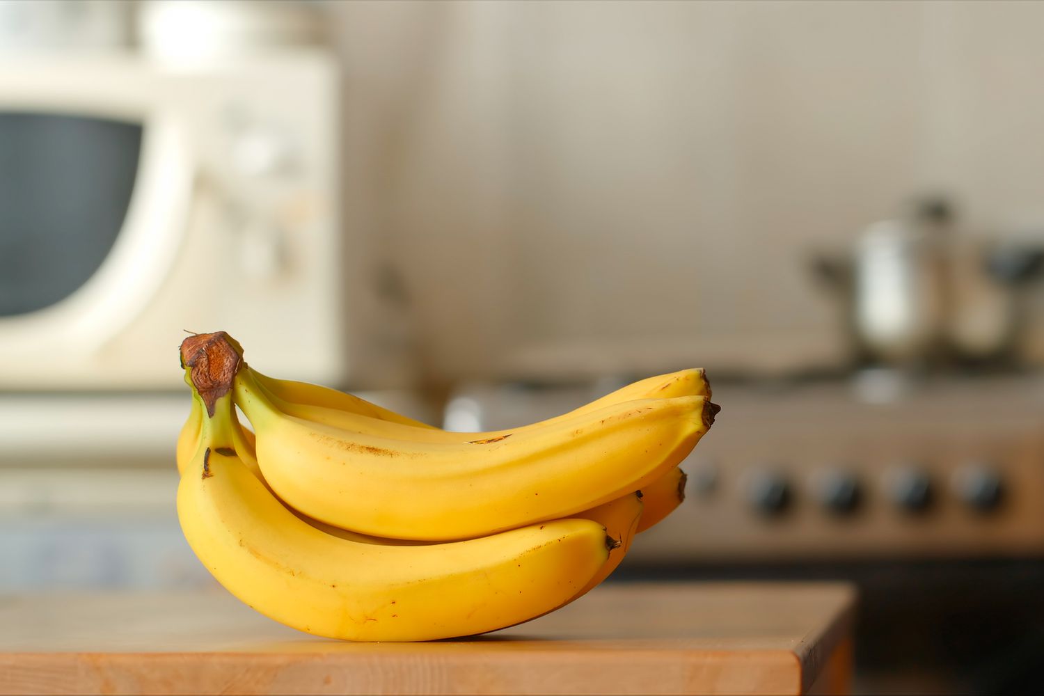 bundle of bananas on the kitchen counter by itself