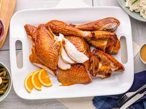 Citrus-brined smoked turkey carved on a platter.