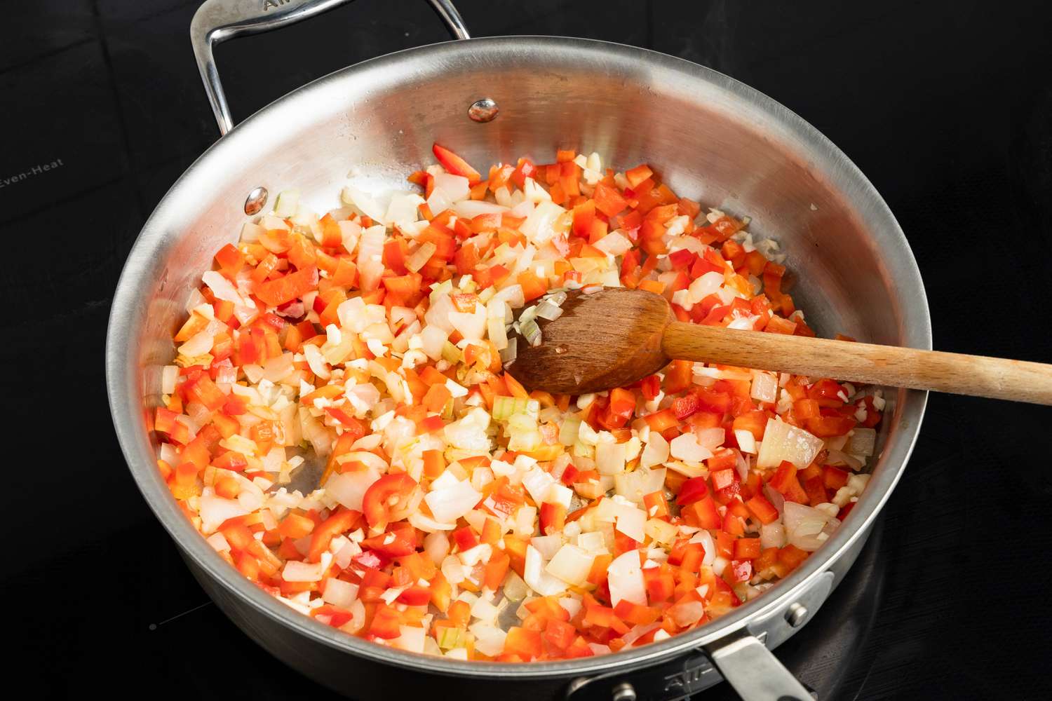 Onions, bell pepper, and garlic cooking in the skillet on the stove for Johnny Marzetti casserole recipe