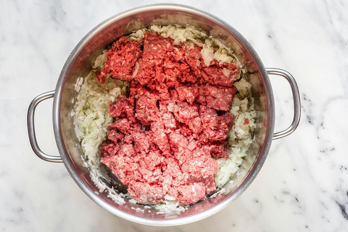 Ground beef and onions in a stock pot to make a Chili recipe.