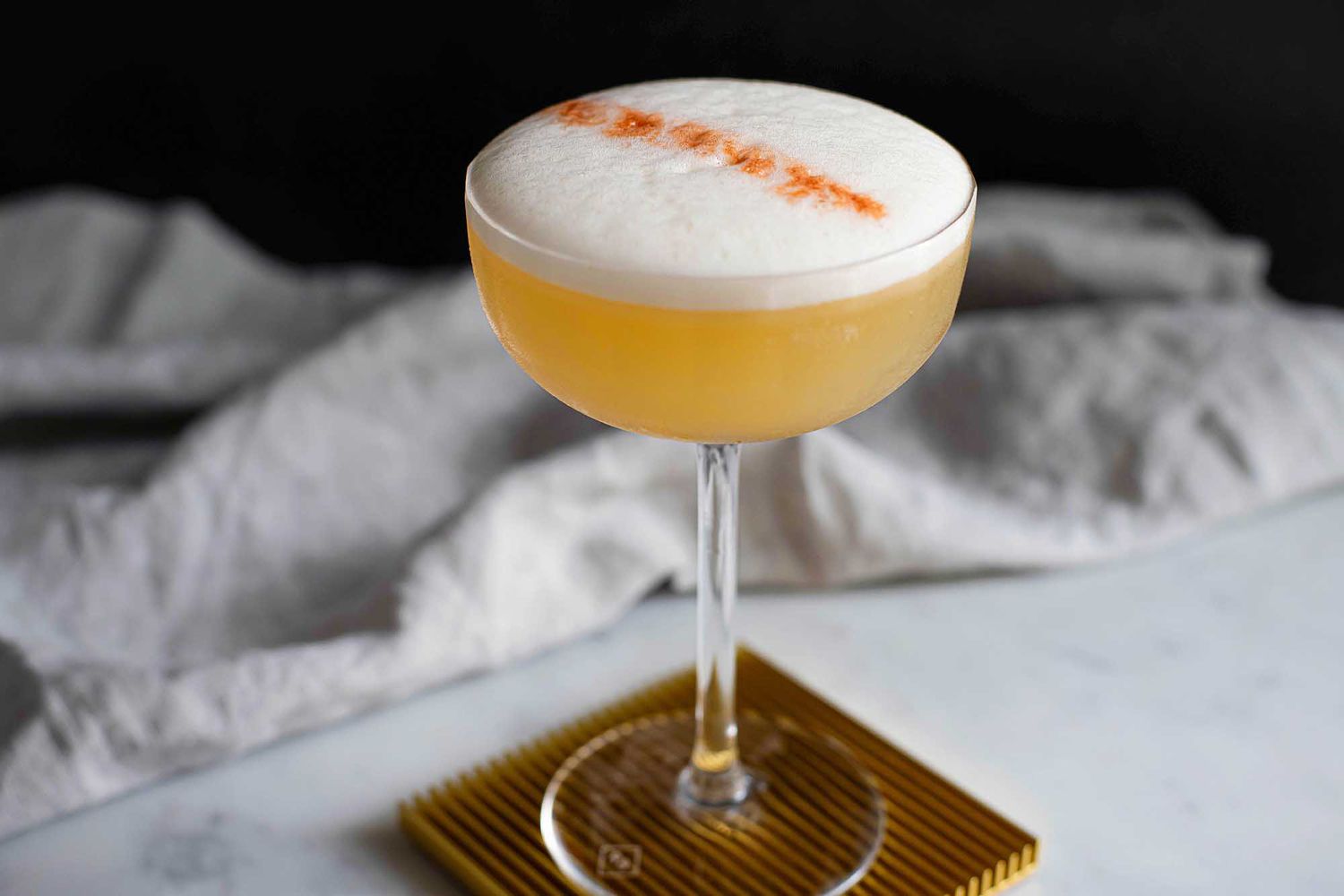 Whiskey Sour straight up in a glass with foam