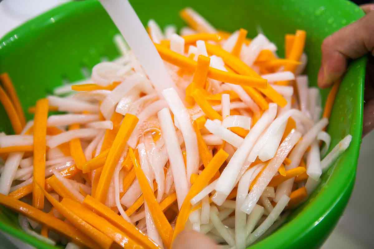 rinsing carrots and daikon for vietnamese pickles for banh mi sandwiches