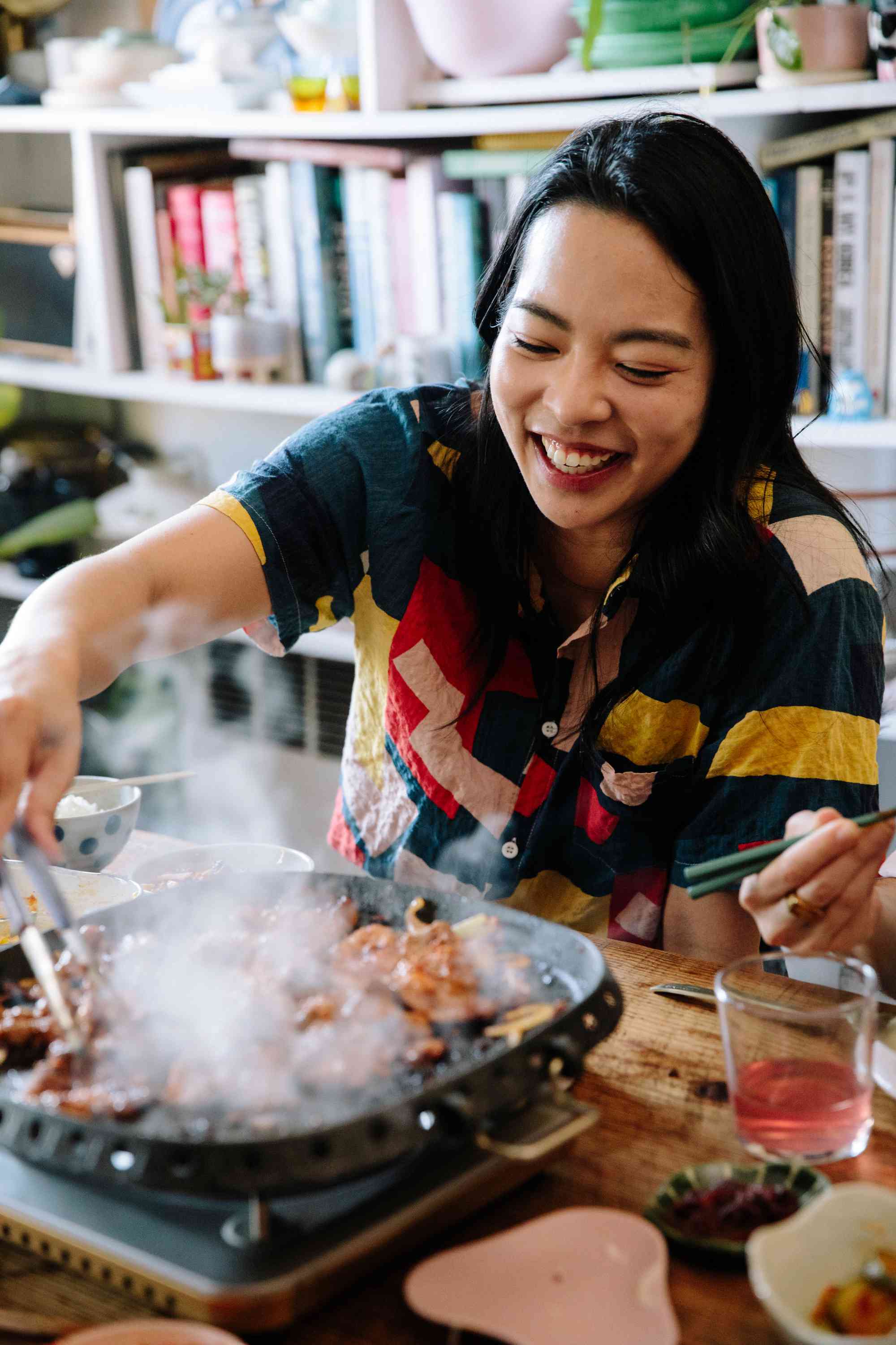 A women reaching for more Korean BBQ