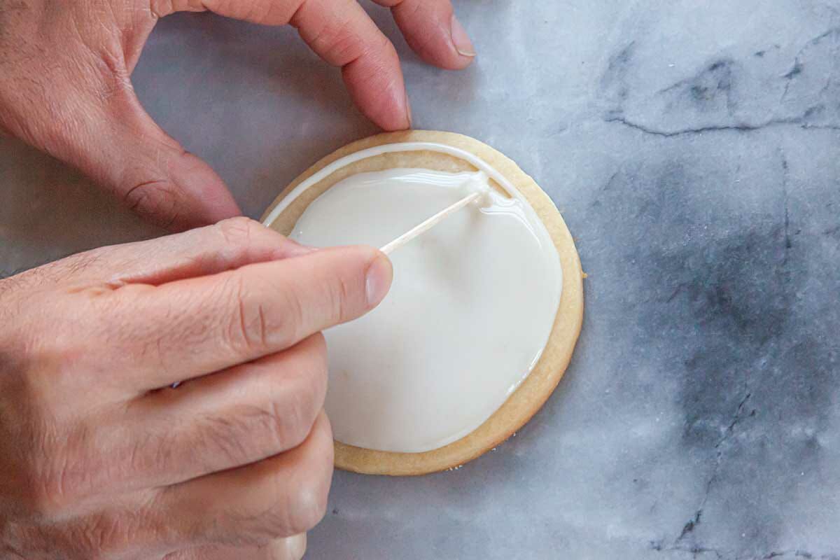 A toothpick used to fill in a sugar cookie with Royal icing.
