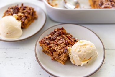 square slice of Pumpkin Dump Cake with a scoop of ice cream on a plate