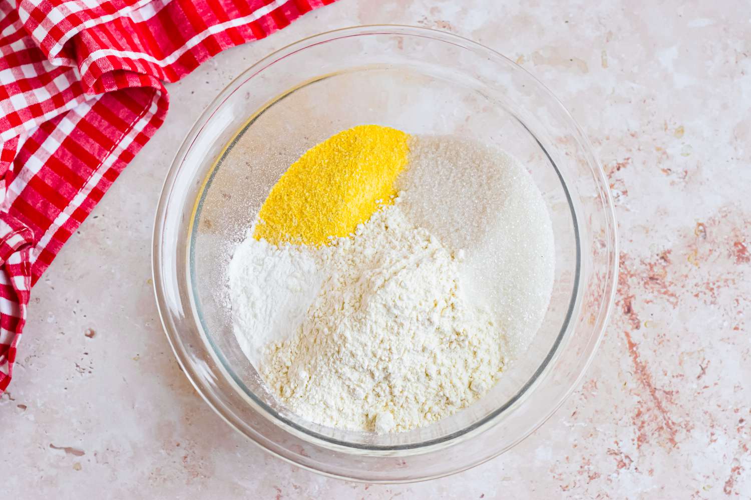 Bowl of Corn Dog Muffin Dry Ingredients Next to a Red and White Checkered Kitchen Towel