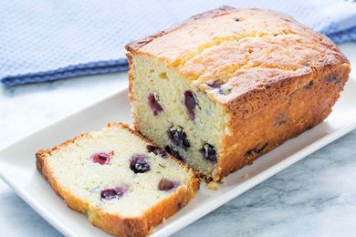 Blueberry lemon ricotta pound cake on a white plate with one slice