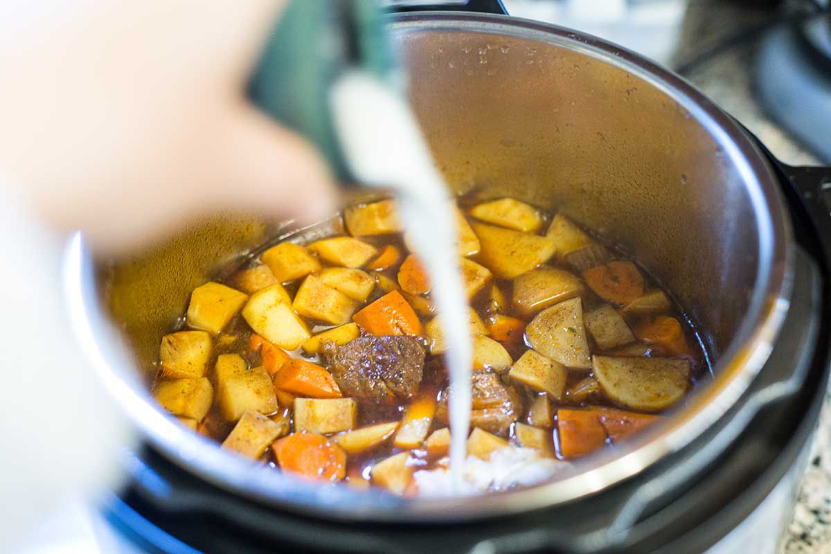 Add corn starch slurry to beef stew to thicken