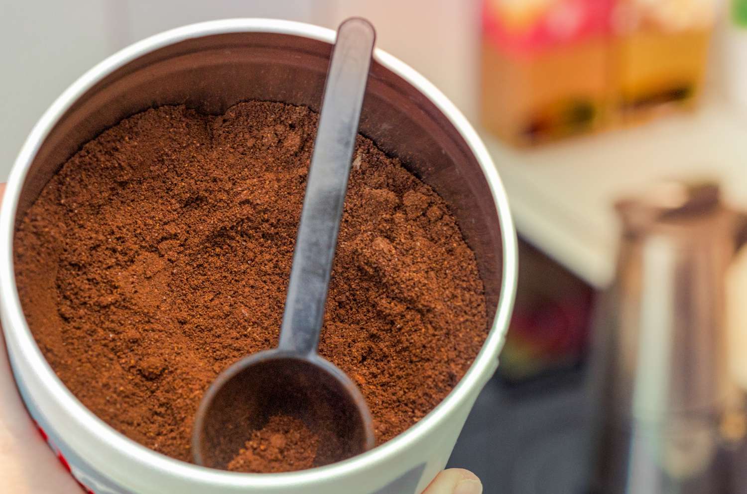 Ground coffee in a jar with a coffee scoop