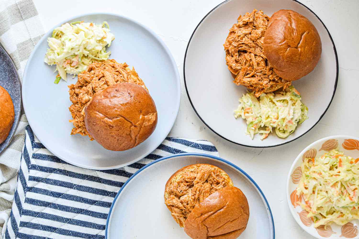 Overhead view of pulled pork sandwiches on plates.