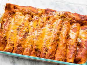 Easy Chicken Enchiladas in pan covered in red chili sauce and cheese
