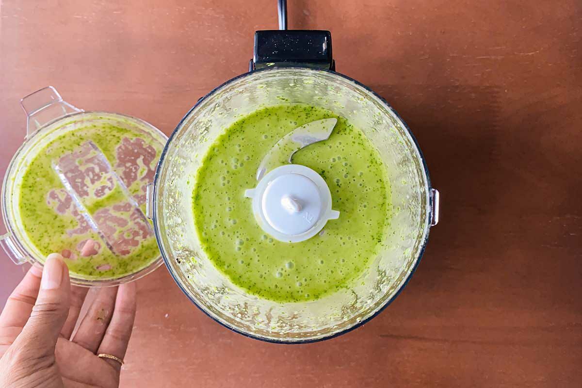An open food processor with basil-lime vinaigrette