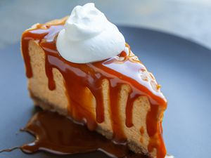 pumpkin cheesecake slice with caramel and whipped cream