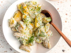tzatziki potato salad in a bowl with a serving spoon
