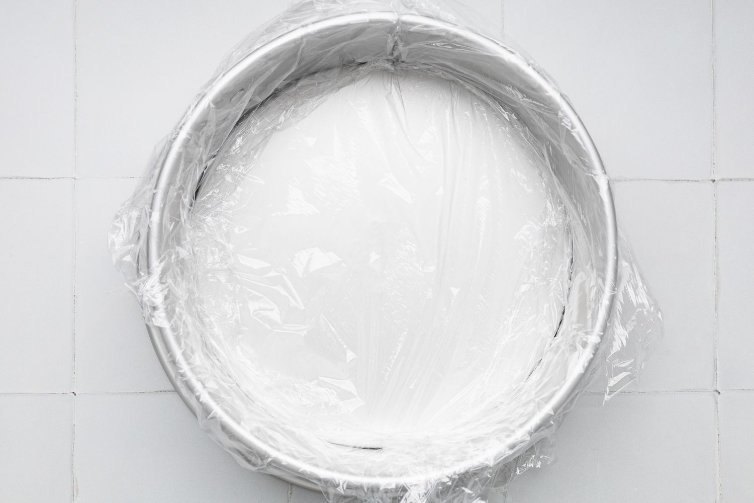 Circular Cake Pan Wrapped in Plastic Wrap for Oreo Cookie Ice Cream Cake Recipe