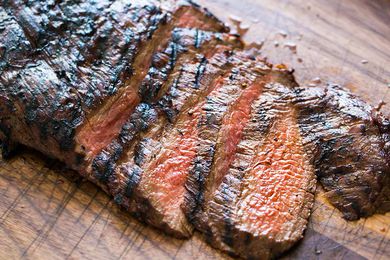 Grilled Marinated Flank Steak sliced on a cutting board