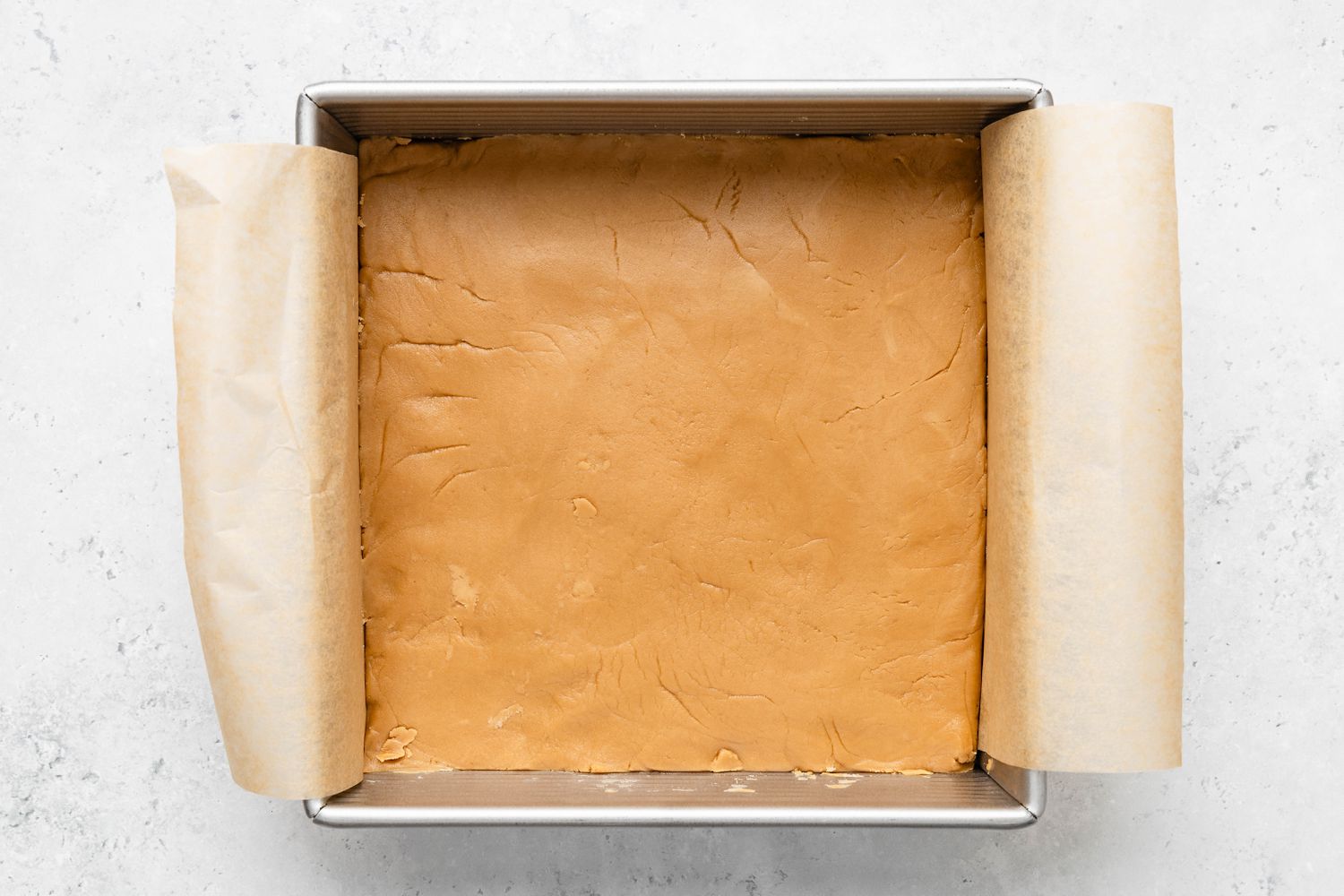 Penuche setting in the parchment paper-lined baking pan