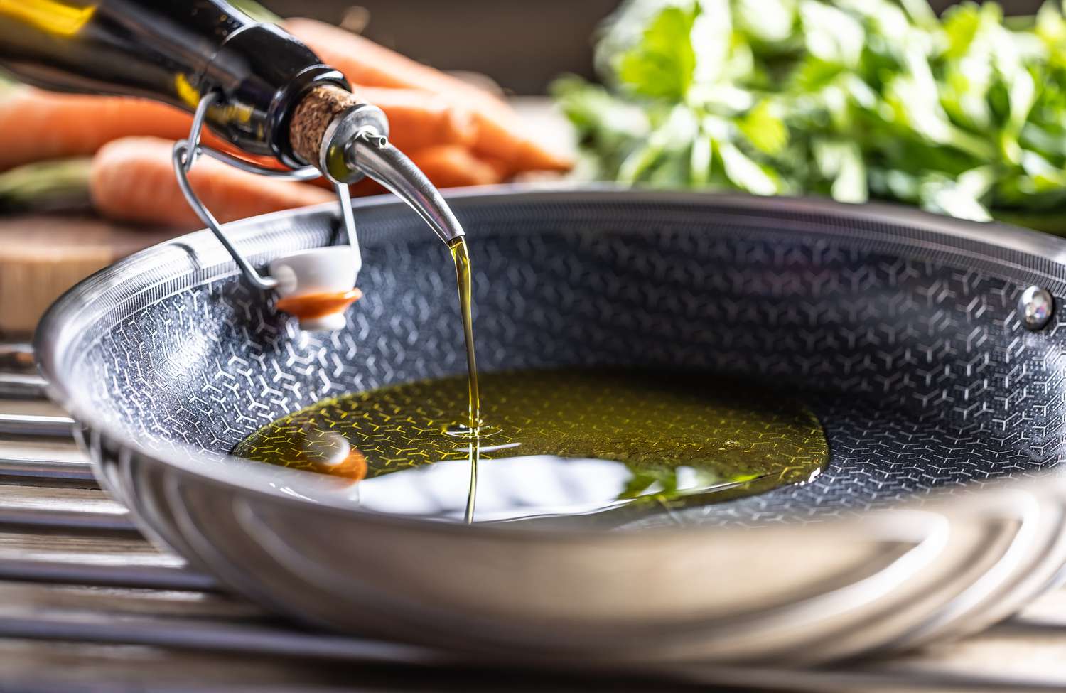 Sideview of oil getting poured into a nonstick pan