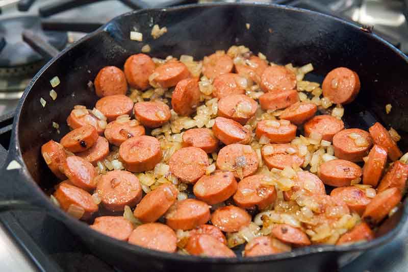 sautéed hot dogs and onions in skillet