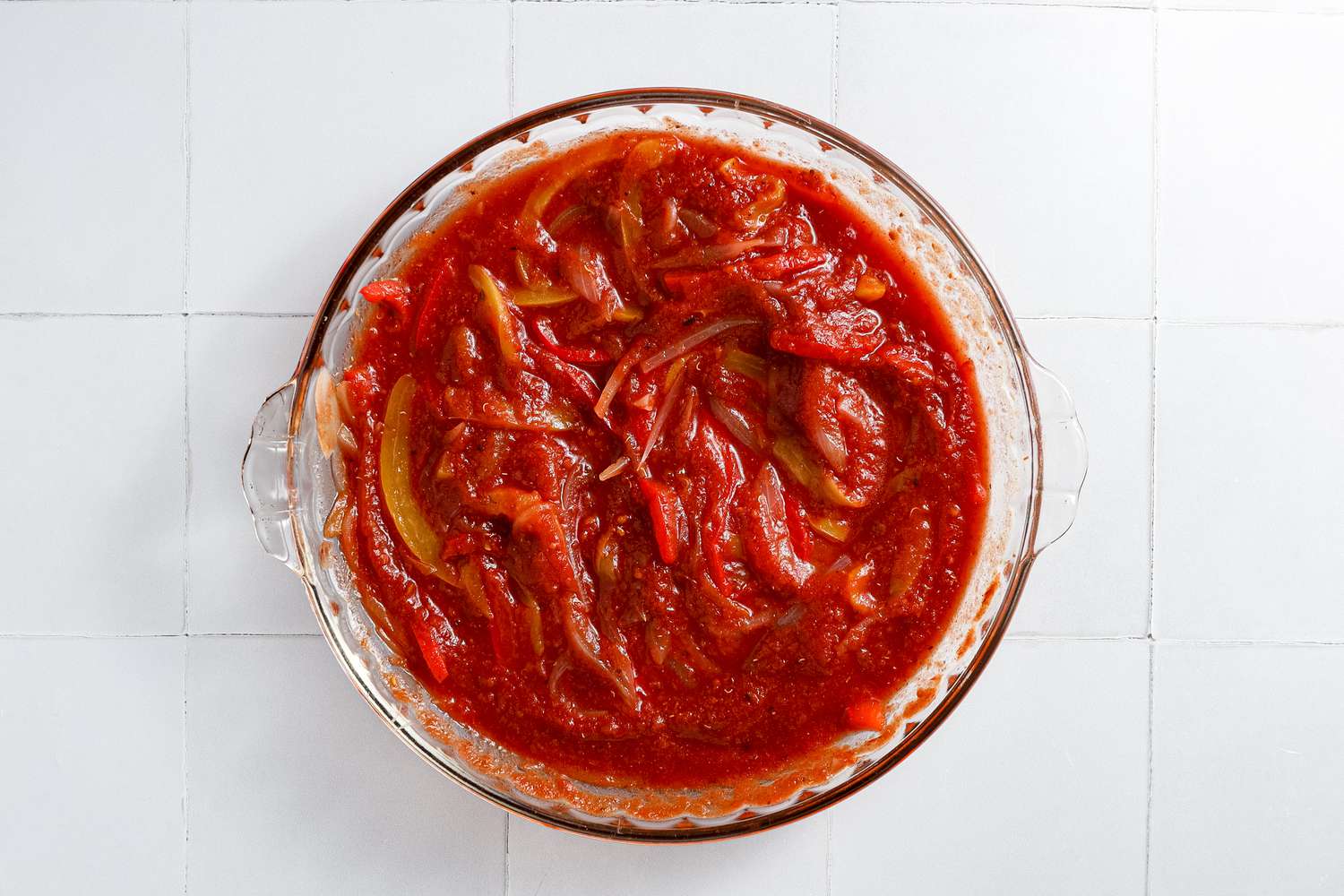 Tomato Sauce and the Rest of the Ingredients Mixed Together in the Glass Pyrex Dish for Microwave Shakshuka 