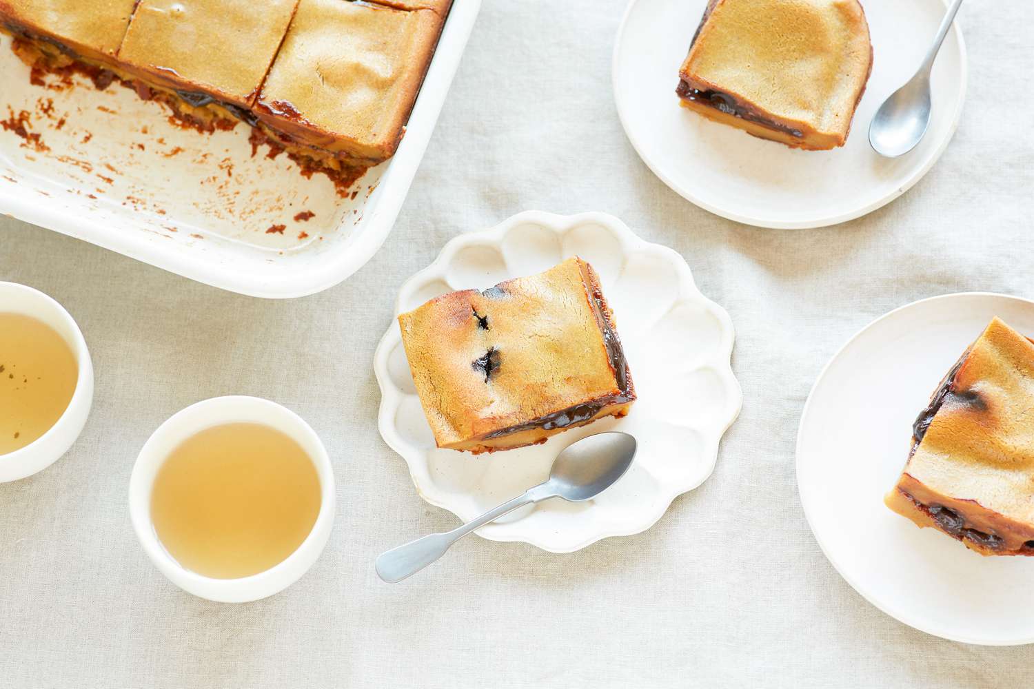 Overhead view of sticky rice cake with red bean paste on plates.