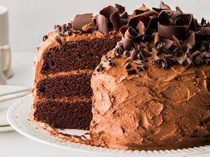 Triple layered chocolate cake topped with a slice missing