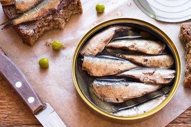 Overhead shot of an open round tin of sardines