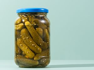 A jar of pickles with a blue lid
