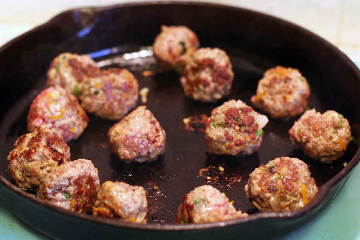 seared greek meatballs in frying pan 