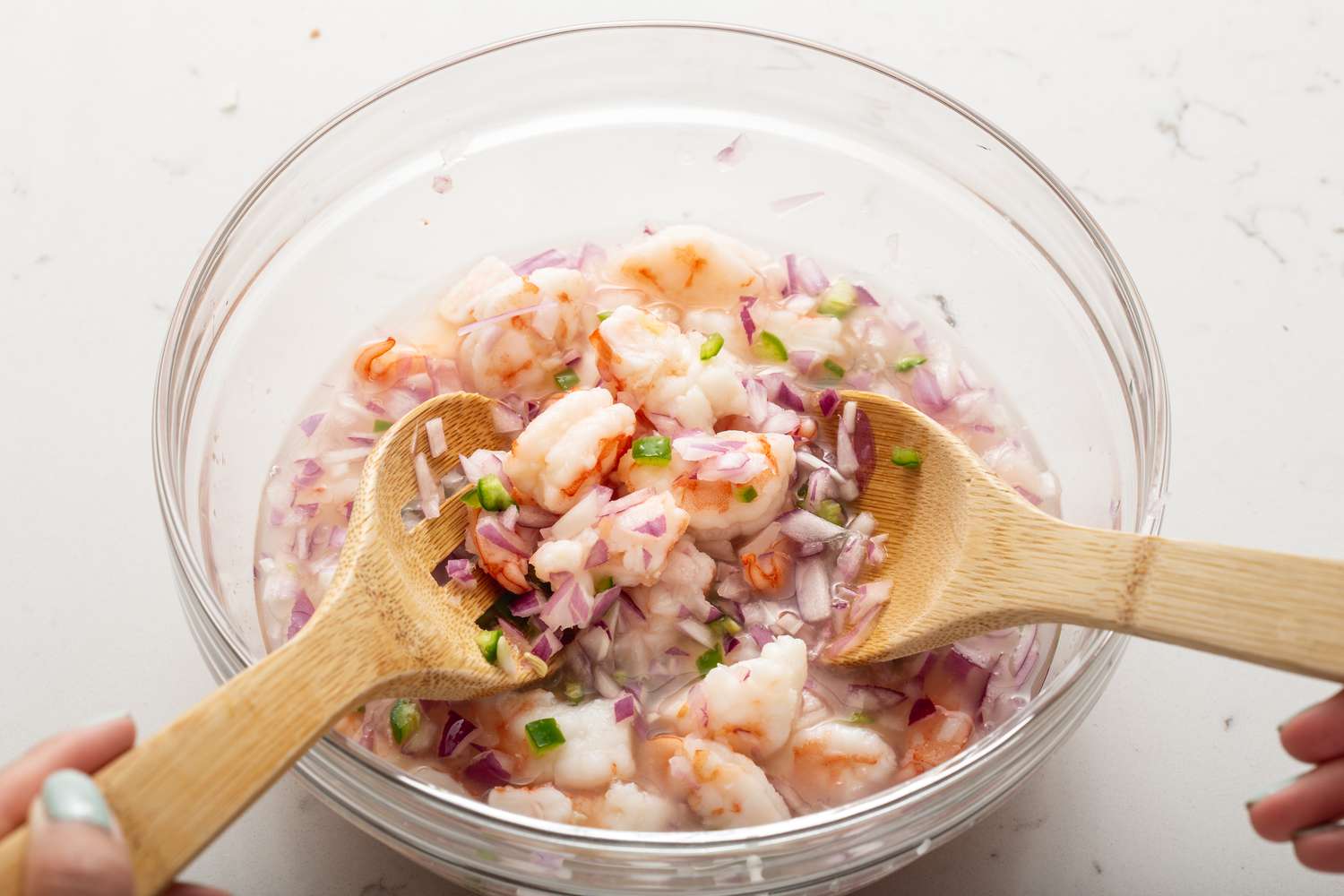Mixing ingredients to show how to make shrimp ceviche.