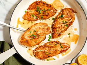 Overhead view of 4-ingredient Garlic-Tahini chicken breast cutlets cooking in a white skillet