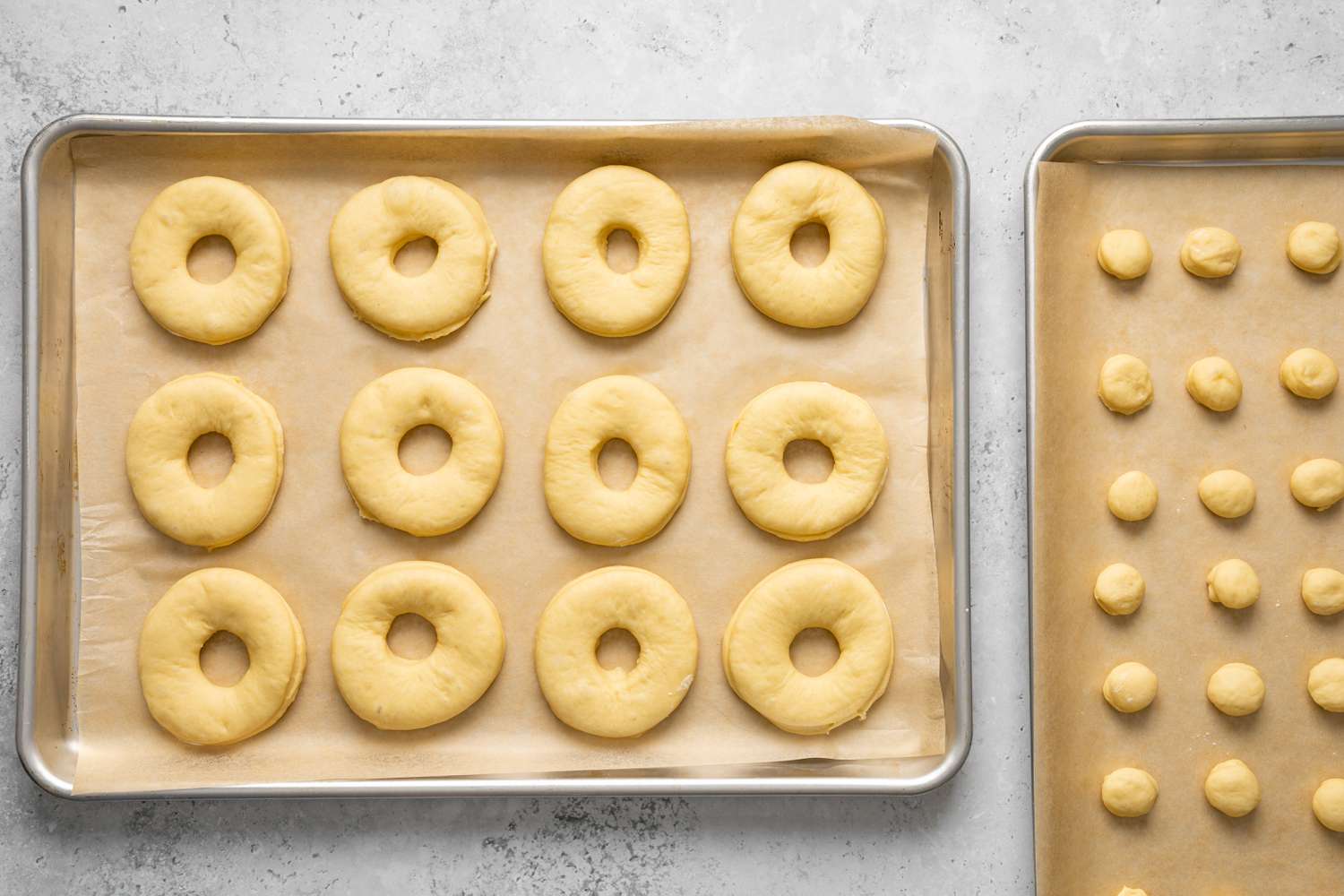 Donuts and Donut Holes Proofing on Two Lined Baking Sheets