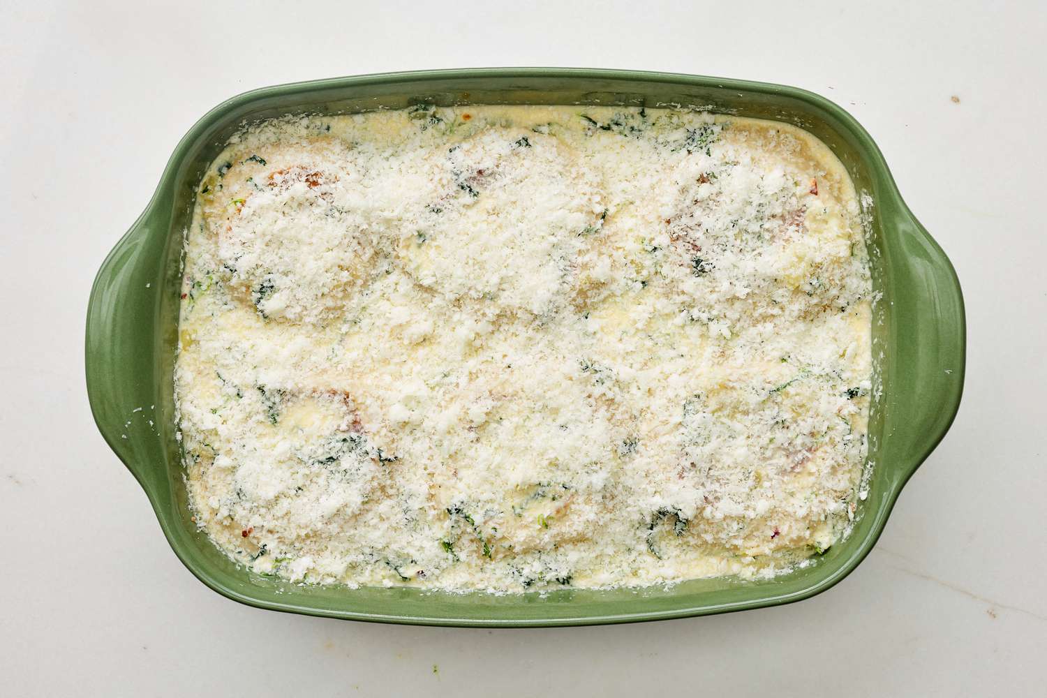 Parmesan added to casserole dish after wet ingredients were poured over the English muffins and filling for spinach flornetine breakfast casserole 