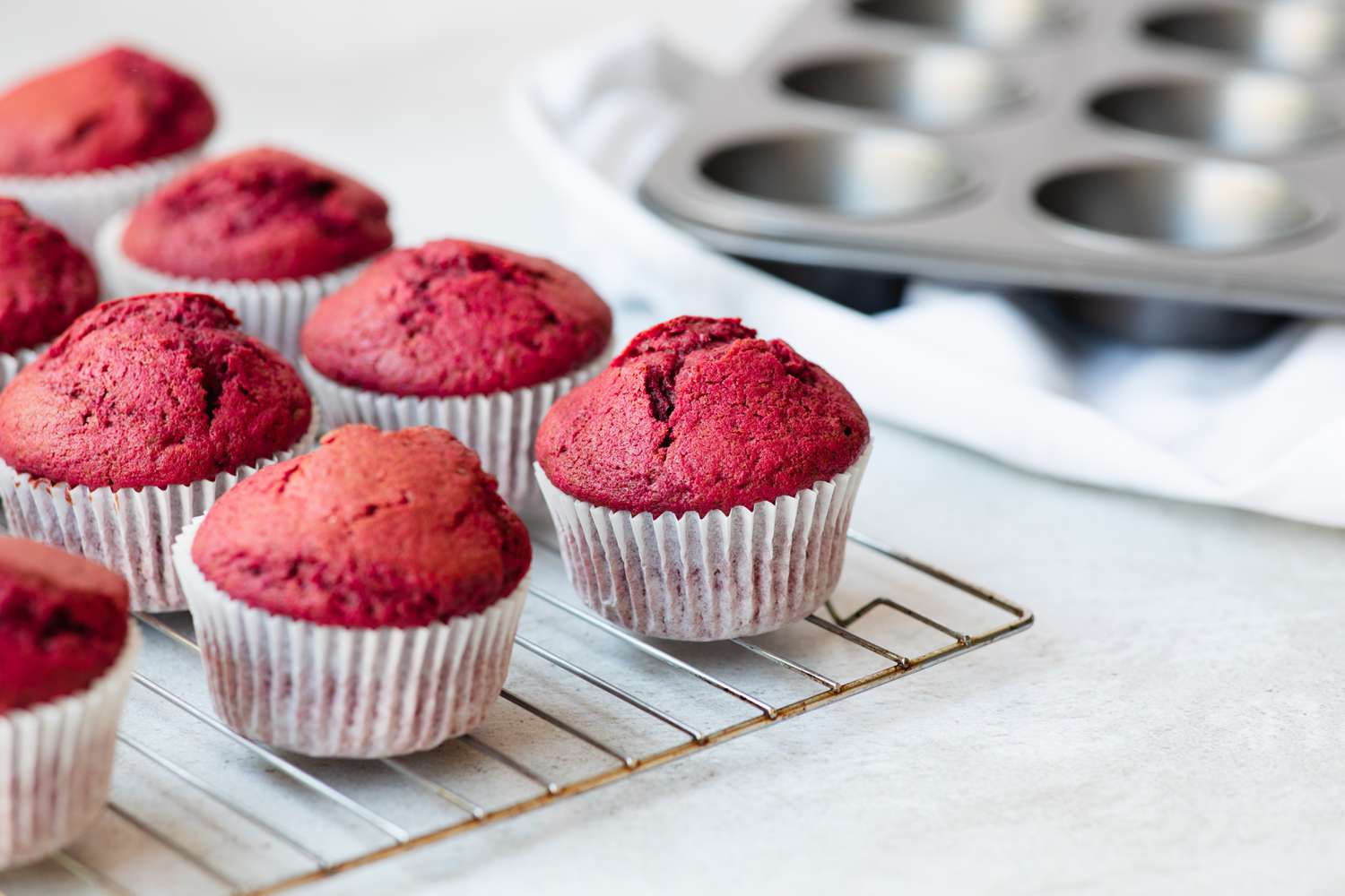 Red velvet cupcakes cooling on a rack.