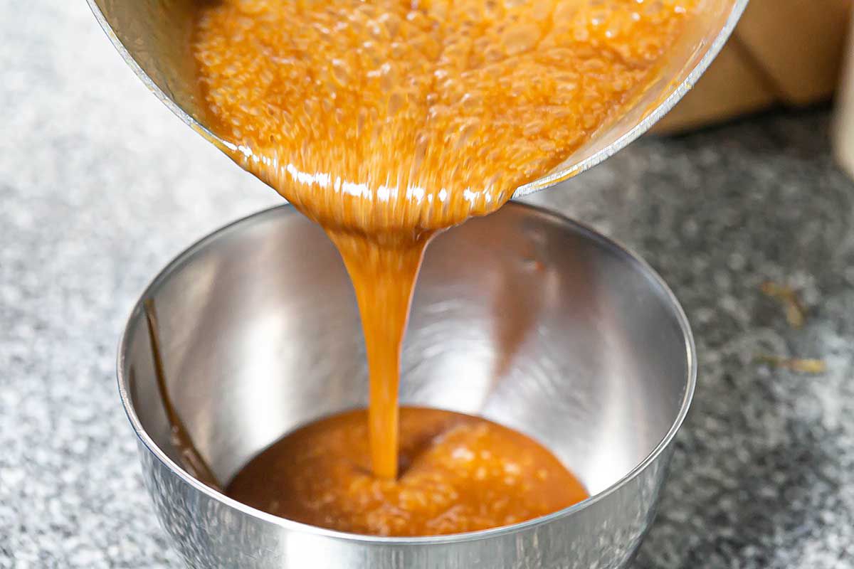 How to Make Caramel Apples pouring the caramel into a bowl