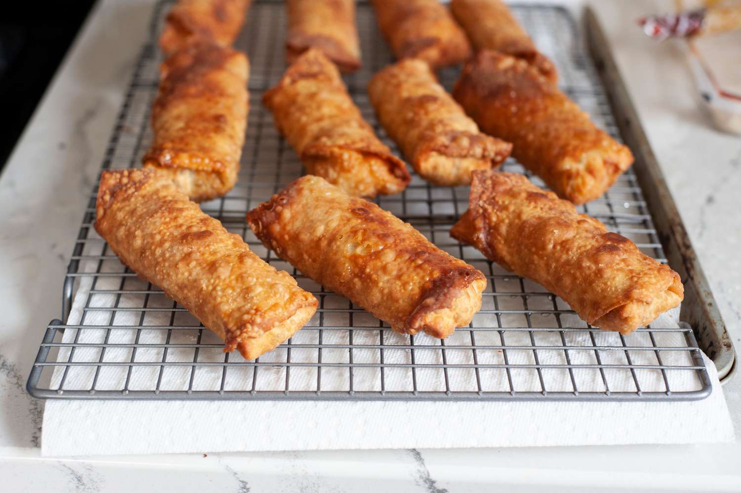 Vegetarian egg rolls cooling on a rack.