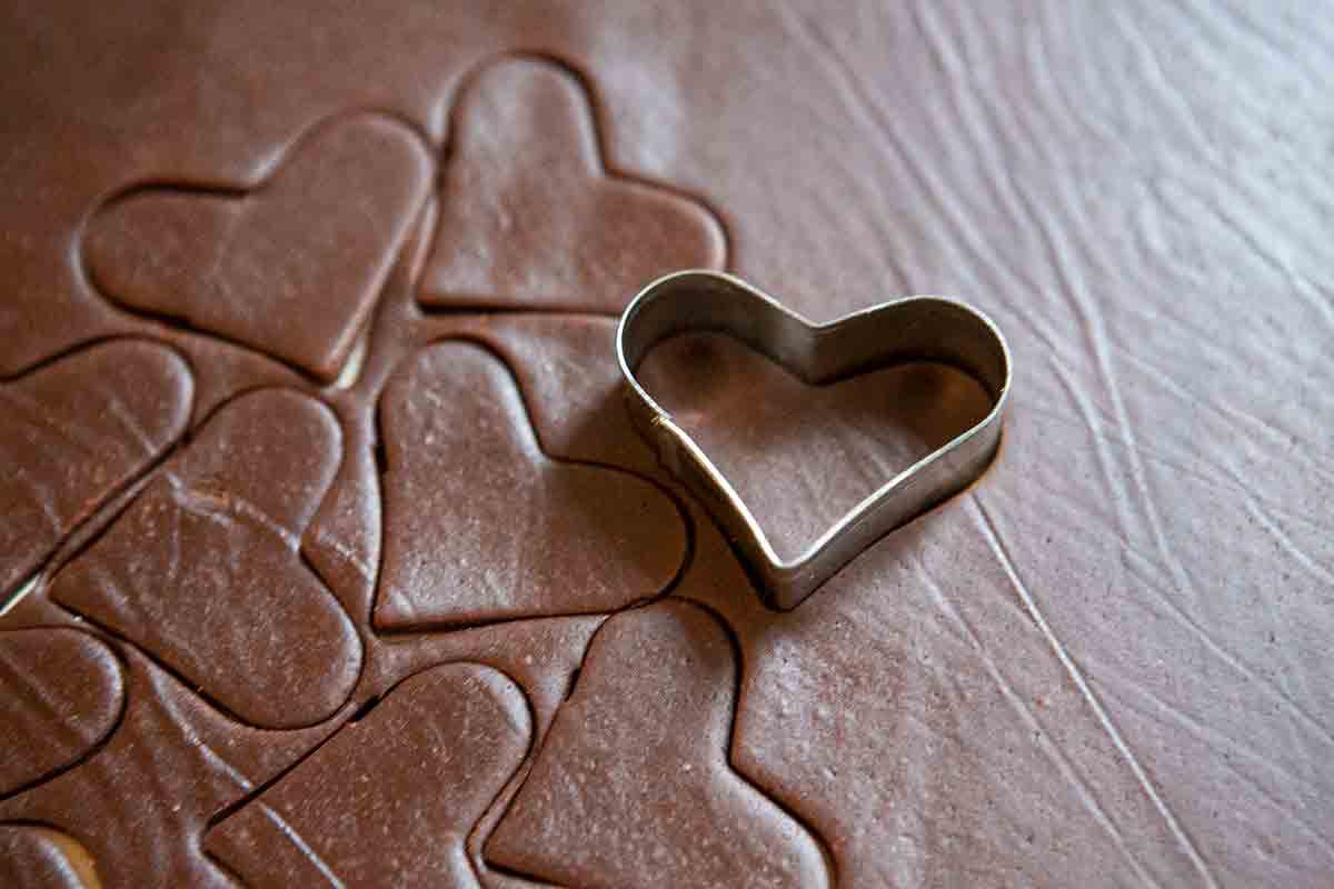 cutting out cookies with a heart-shaped cookie cutter